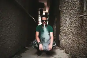 人物在戶外吐出電子煙氣霧的使用情境畫面